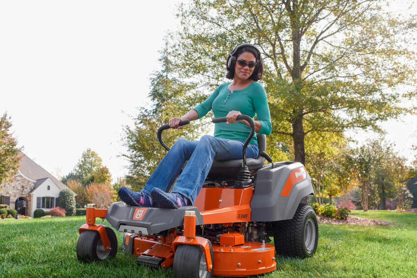 woman on zero turn mower in backyard